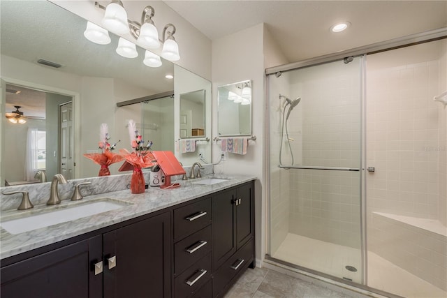 bathroom with ceiling fan, vanity, a textured ceiling, and walk in shower