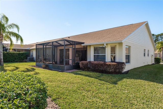 rear view of property featuring central AC, a yard, and glass enclosure