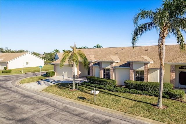 ranch-style home with a garage and a front yard