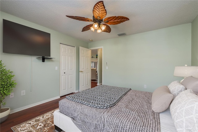 bedroom with a textured ceiling, dark hardwood / wood-style floors, and ceiling fan