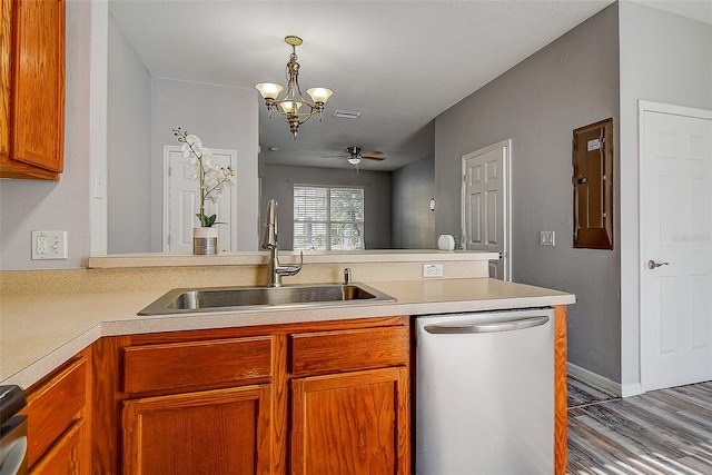 kitchen with kitchen peninsula, stainless steel dishwasher, ceiling fan with notable chandelier, sink, and pendant lighting