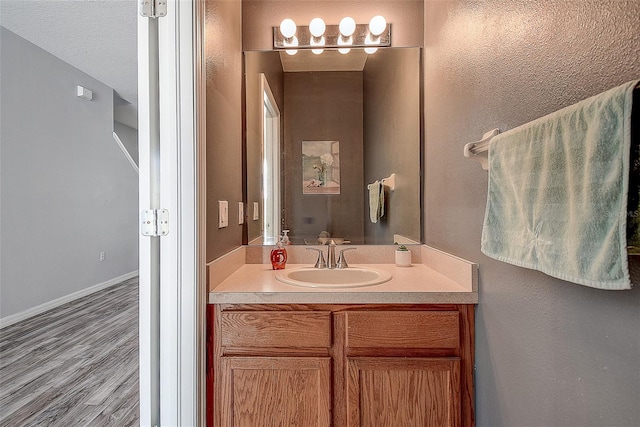 bathroom with vanity, wood-type flooring, and a textured ceiling