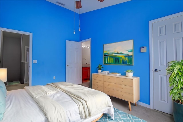 carpeted bedroom with ceiling fan and ensuite bathroom