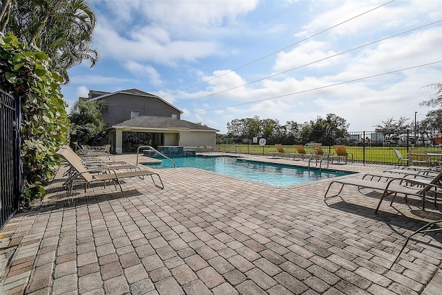 view of swimming pool featuring a patio area and a hot tub