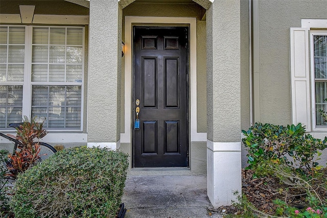 property entrance with stucco siding