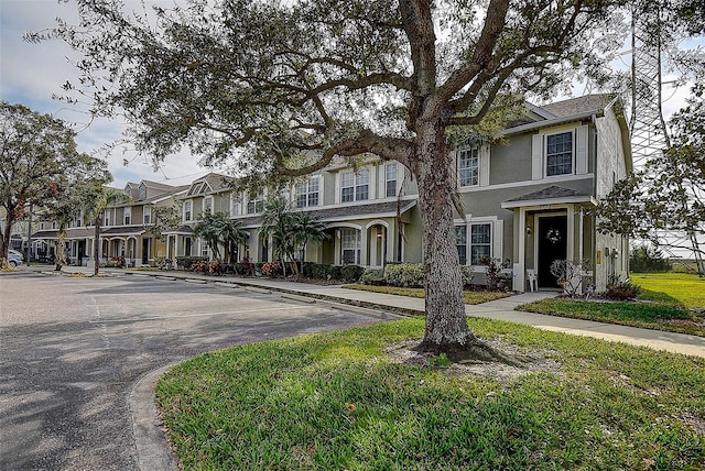 view of property featuring a residential view, stucco siding, and uncovered parking