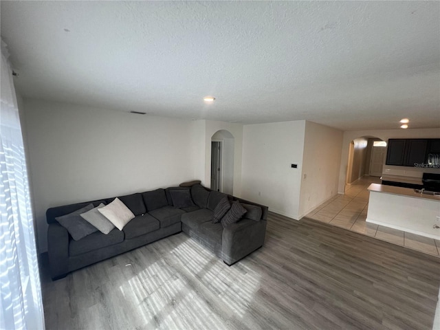 unfurnished living room featuring a textured ceiling and light hardwood / wood-style flooring