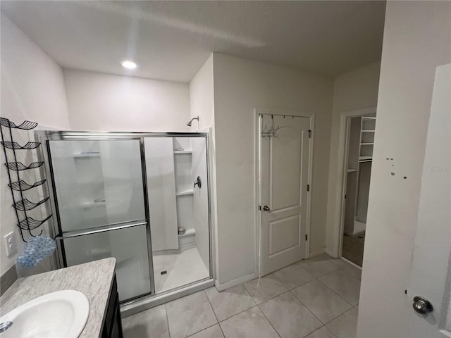 bathroom with tile patterned flooring, vanity, and an enclosed shower