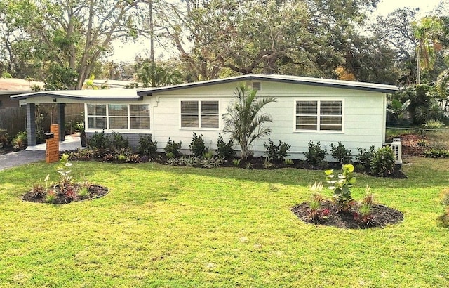 view of front of home with a carport and a front yard