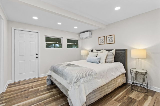 bedroom with dark hardwood / wood-style flooring, a wall mounted air conditioner, and beam ceiling