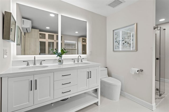 bathroom featuring tile patterned floors, vanity, toilet, and a wall unit AC