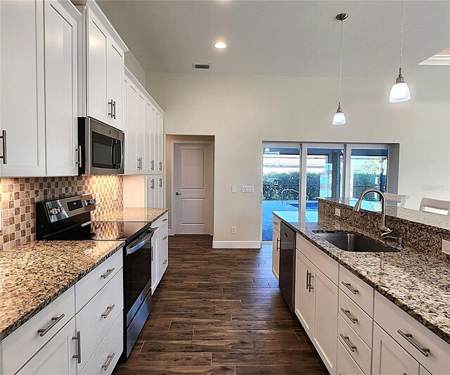 kitchen featuring hanging light fixtures, sink, appliances with stainless steel finishes, light stone counters, and white cabinetry