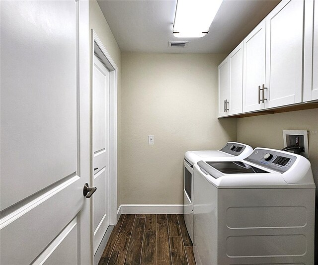 clothes washing area with cabinets and washer and clothes dryer