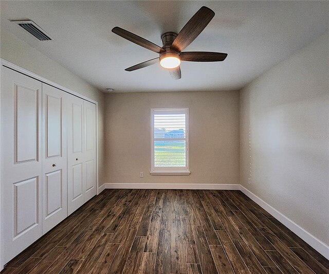 unfurnished bedroom with ceiling fan and a closet