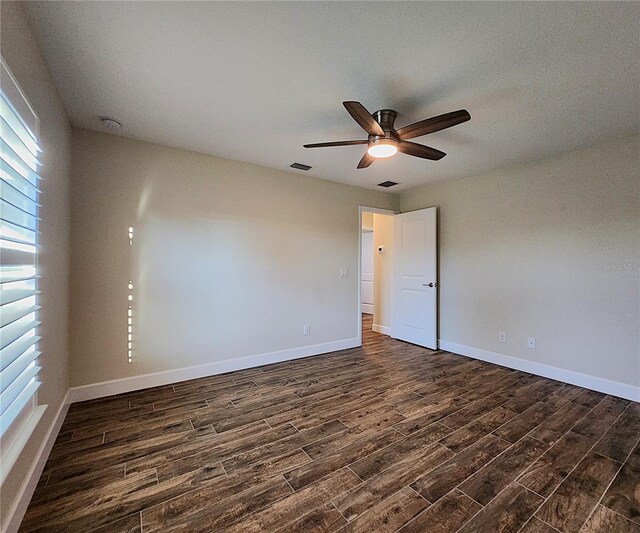 empty room with dark hardwood / wood-style floors and ceiling fan