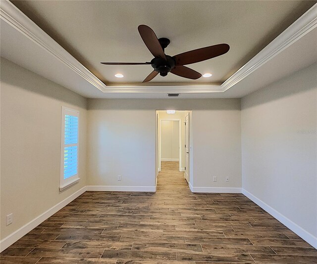 empty room featuring hardwood / wood-style floors, ceiling fan, and a tray ceiling