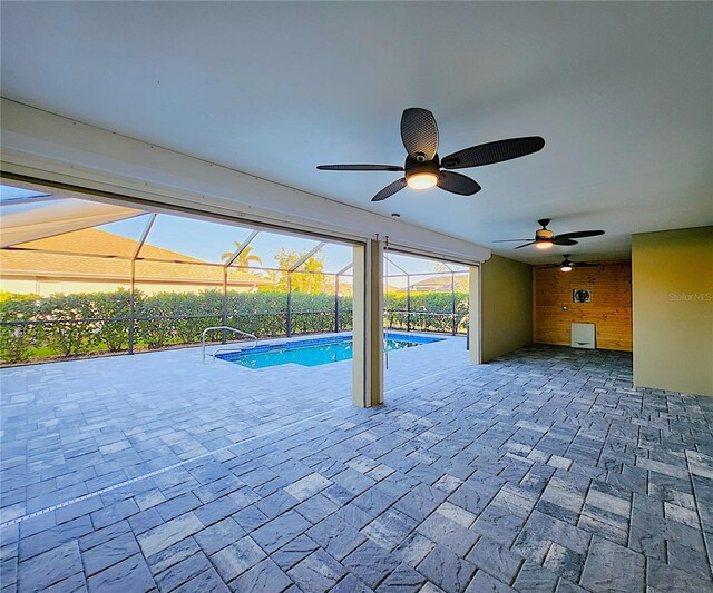 view of swimming pool featuring ceiling fan, a patio area, and a lanai