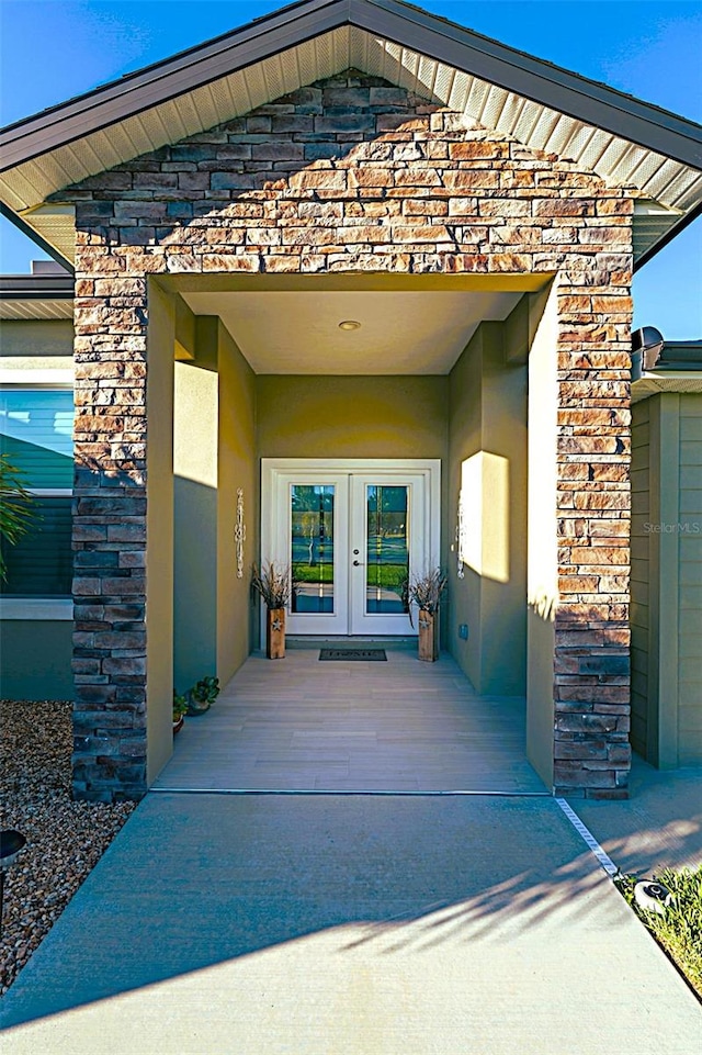 8610 Quinn Ct, North Port, FL 34287 - view of exterior entry featuring stucco siding, french doors, and stone siding