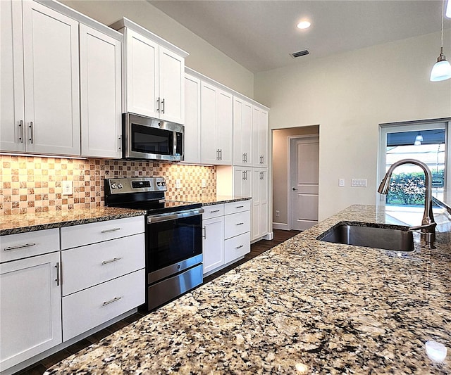 8610 Quinn Ct, North Port, FL 34287 - kitchen featuring visible vents, decorative backsplash, stone countertops, a sink, and appliances with stainless steel finishes