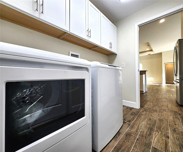 8610 Quinn Ct, North Port, FL 34287 - laundry area with dark wood finished floors, cabinet space, baseboards, recessed lighting, and washer and clothes dryer