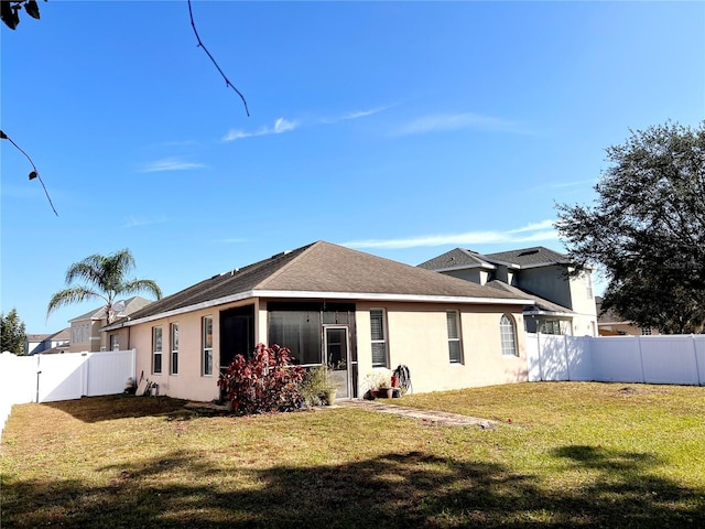 back of property featuring a sunroom and a yard