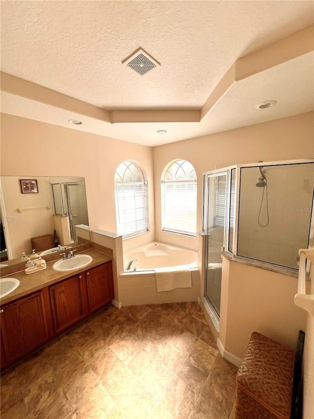 bathroom with vanity, plus walk in shower, and a textured ceiling