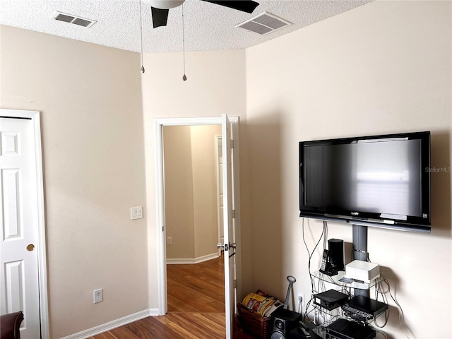 bedroom featuring hardwood / wood-style floors, a textured ceiling, and ceiling fan