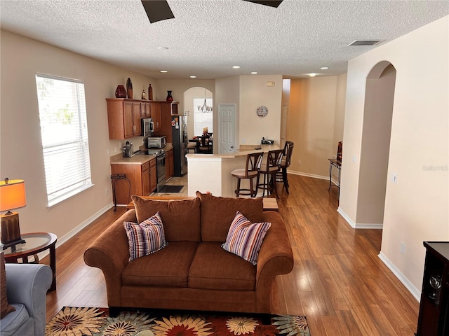 living room with a textured ceiling and light hardwood / wood-style floors