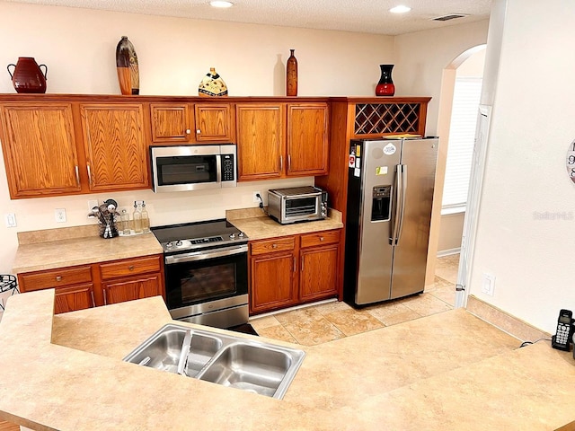 kitchen featuring sink, a textured ceiling, and appliances with stainless steel finishes