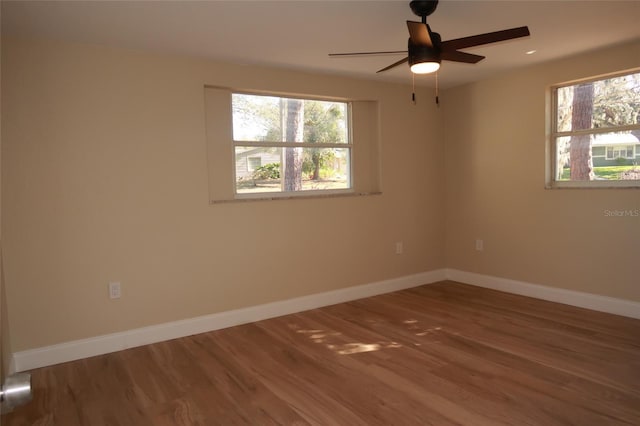 empty room with ceiling fan and hardwood / wood-style flooring