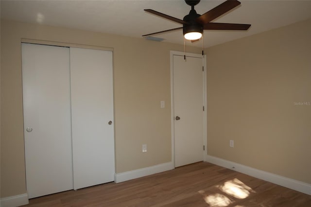 unfurnished bedroom featuring ceiling fan, a closet, and light wood-type flooring