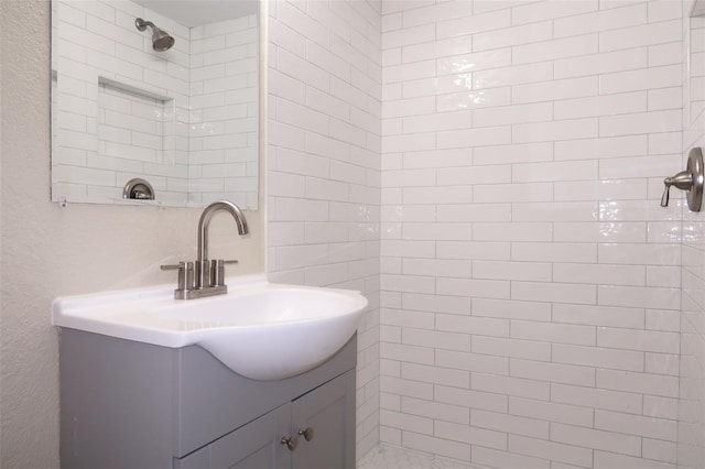 full bath featuring vanity and a tile shower
