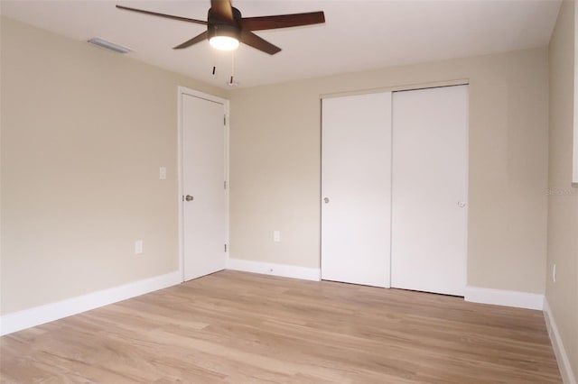 unfurnished bedroom with light wood-style floors, baseboards, a closet, and visible vents