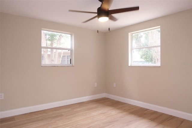 spare room featuring ceiling fan, baseboards, and light wood-style floors