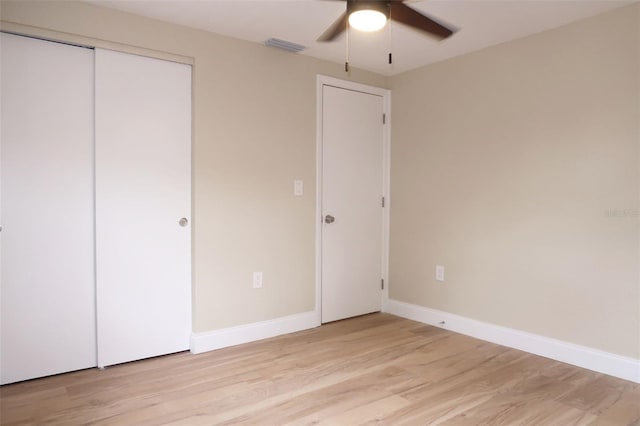unfurnished bedroom featuring visible vents, a closet, baseboards, ceiling fan, and light wood-type flooring