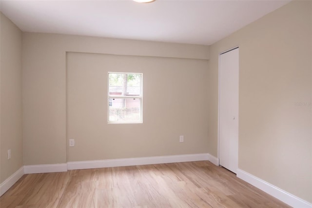 unfurnished room featuring baseboards and light wood-style floors