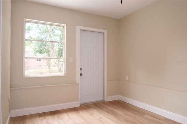 unfurnished room with baseboards and light wood-style flooring