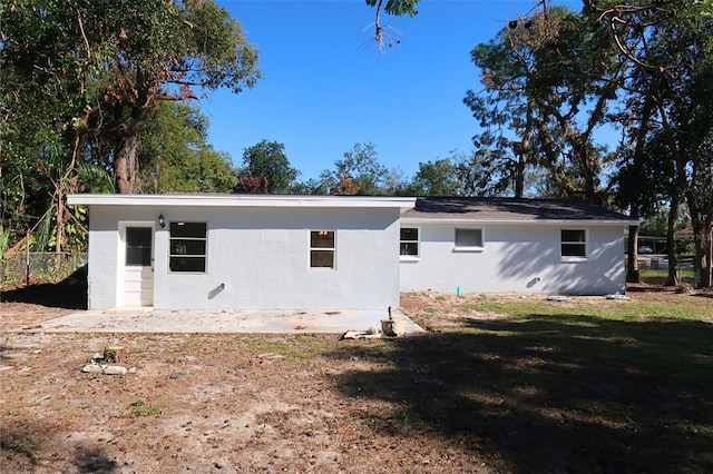 view of home's exterior featuring a lawn, fence, and stucco siding