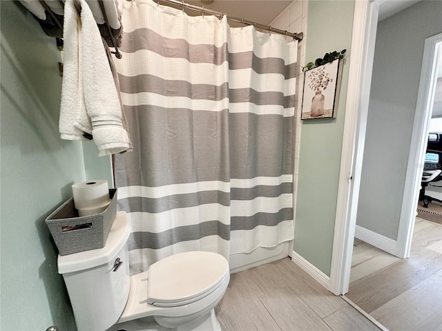 bathroom featuring shower / bath combo with shower curtain and toilet