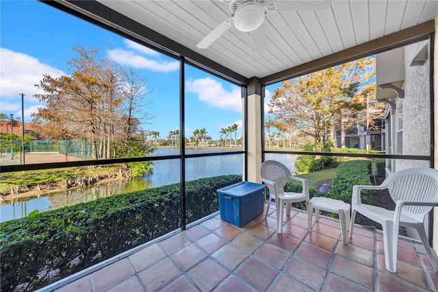 sunroom / solarium featuring ceiling fan and a water view