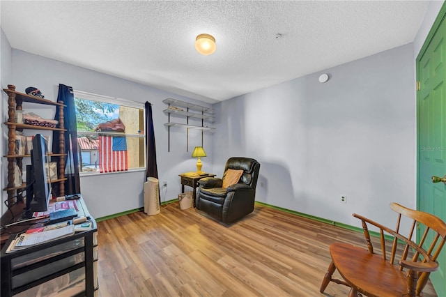 sitting room featuring light hardwood / wood-style floors and a textured ceiling