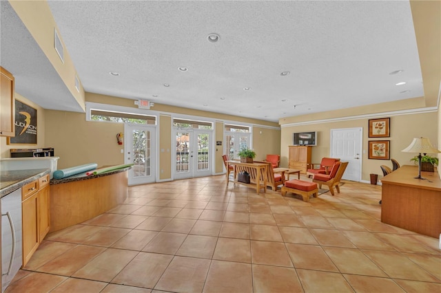 dining space featuring french doors, a textured ceiling, and light tile patterned flooring