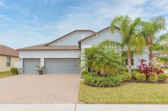 view of front of home featuring a front lawn and a garage