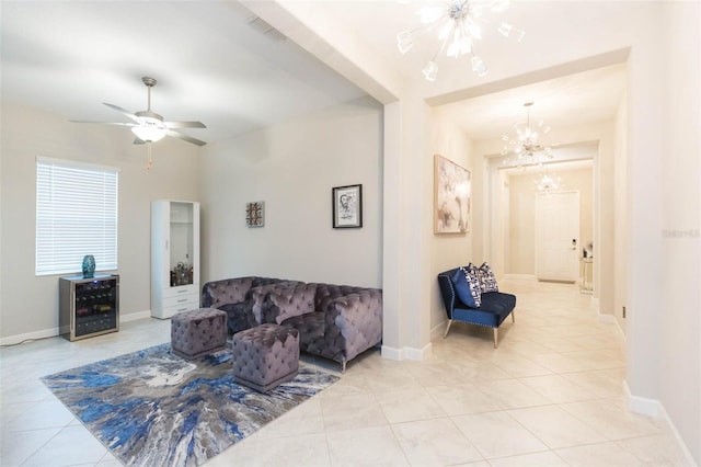 tiled living room with ceiling fan with notable chandelier