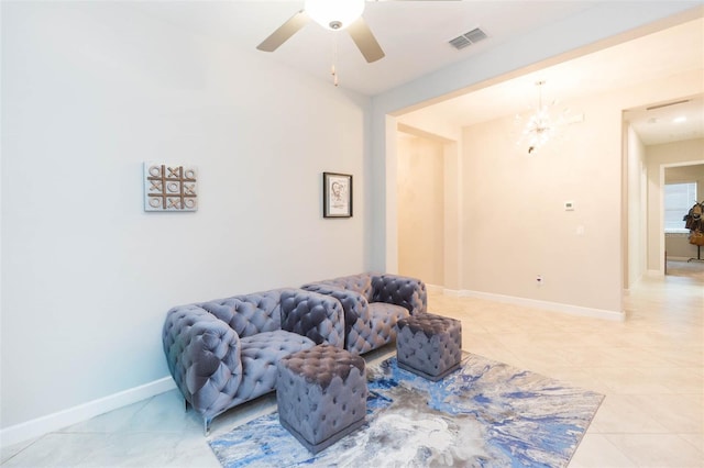 sitting room with ceiling fan with notable chandelier and light tile patterned floors