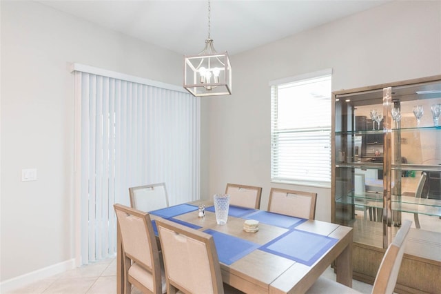 tiled dining room featuring an inviting chandelier