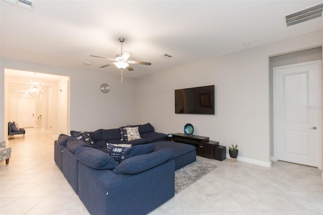 living room with ceiling fan with notable chandelier and light tile patterned floors