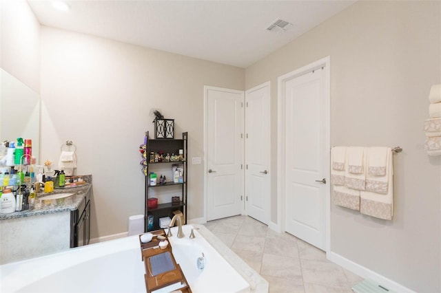 bathroom with tile patterned flooring, a bathtub, and vanity