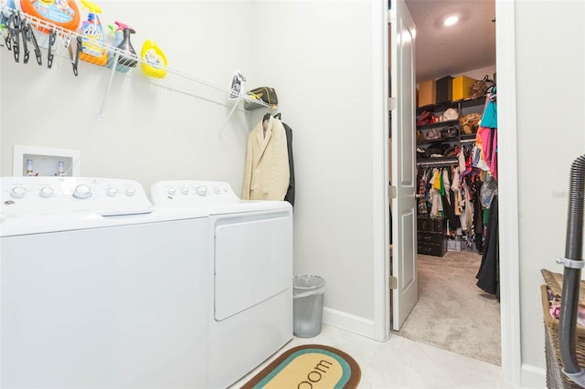 clothes washing area featuring light colored carpet and washing machine and dryer