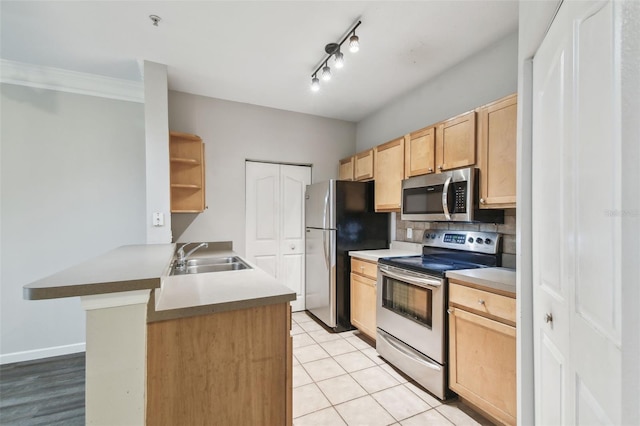 kitchen with sink, light brown cabinets, backsplash, kitchen peninsula, and appliances with stainless steel finishes